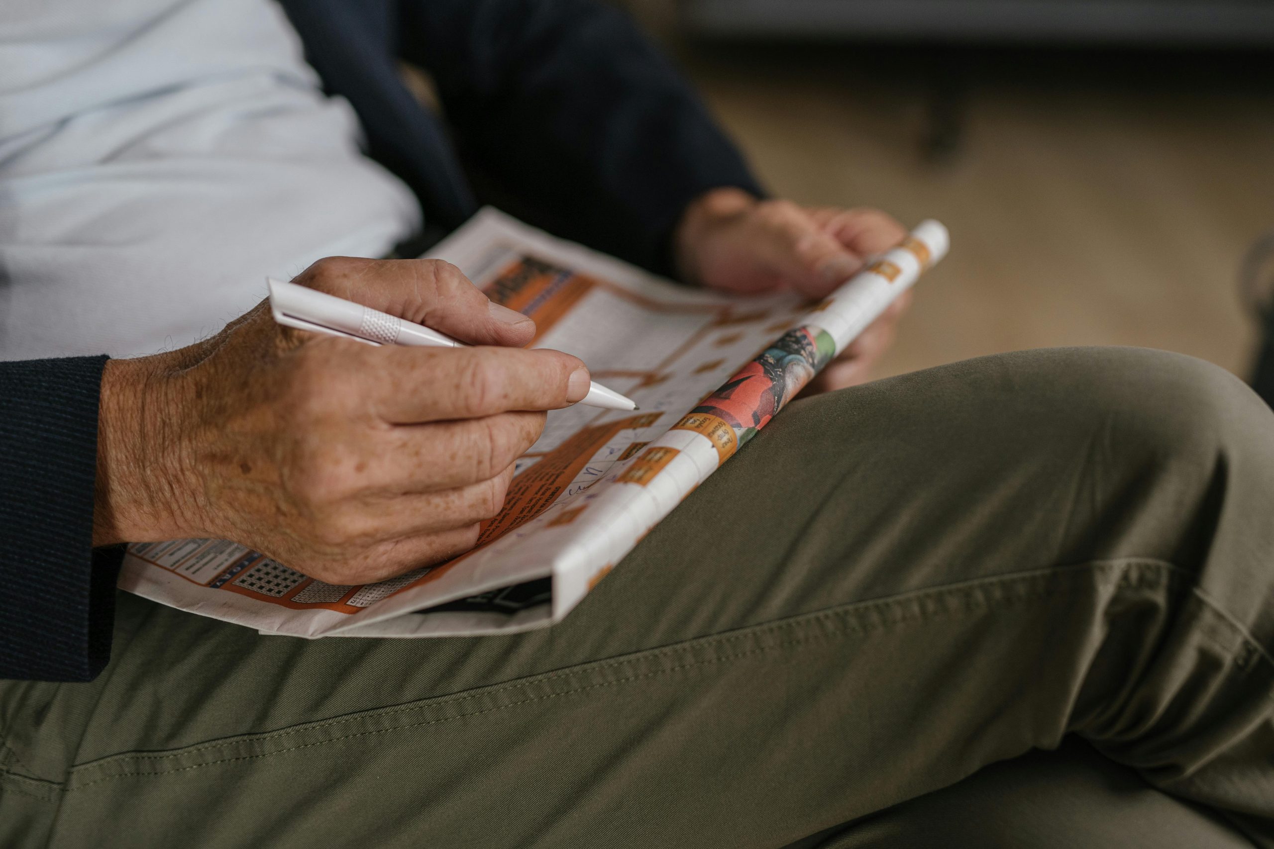 a man does a crossword puzzle in the newspaper